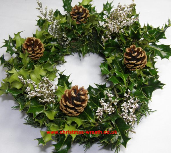 Dressed holly wreath with pine cones and statice
